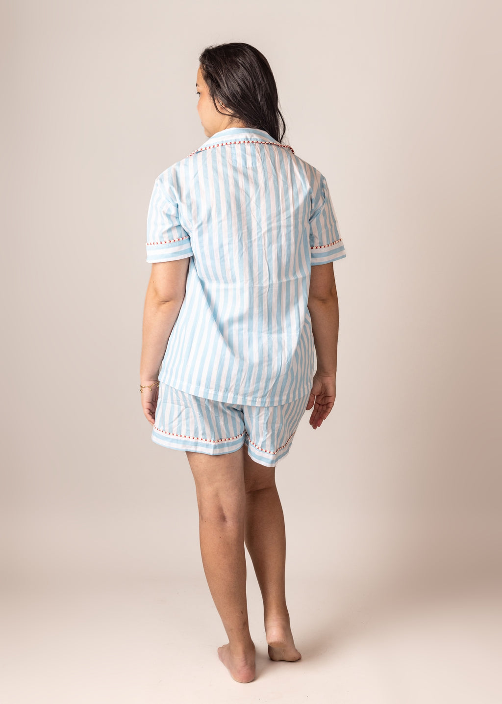Woman wearing a light blue striped pajama set on the back
