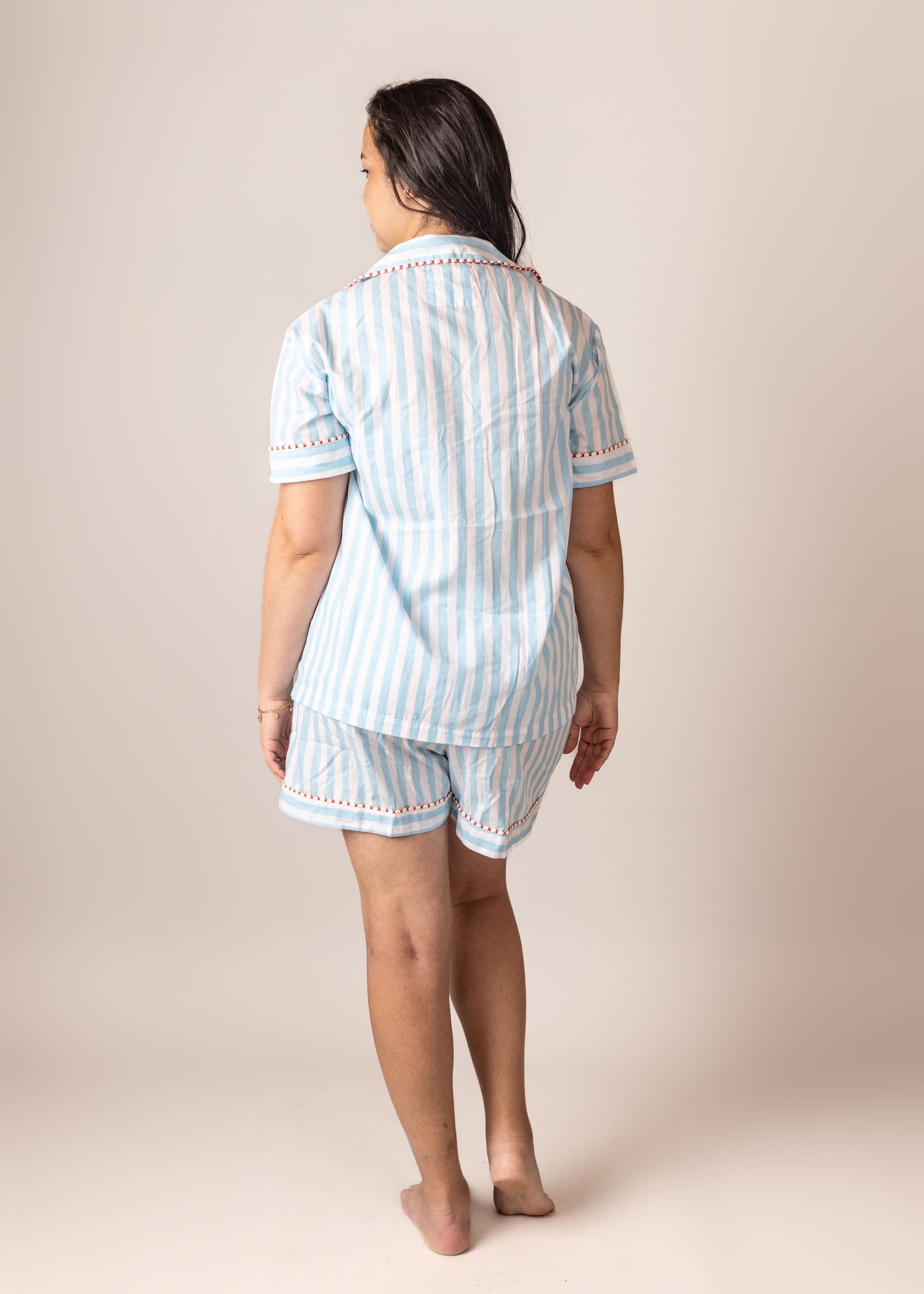 Woman wearing a light blue striped pajama set on the back
