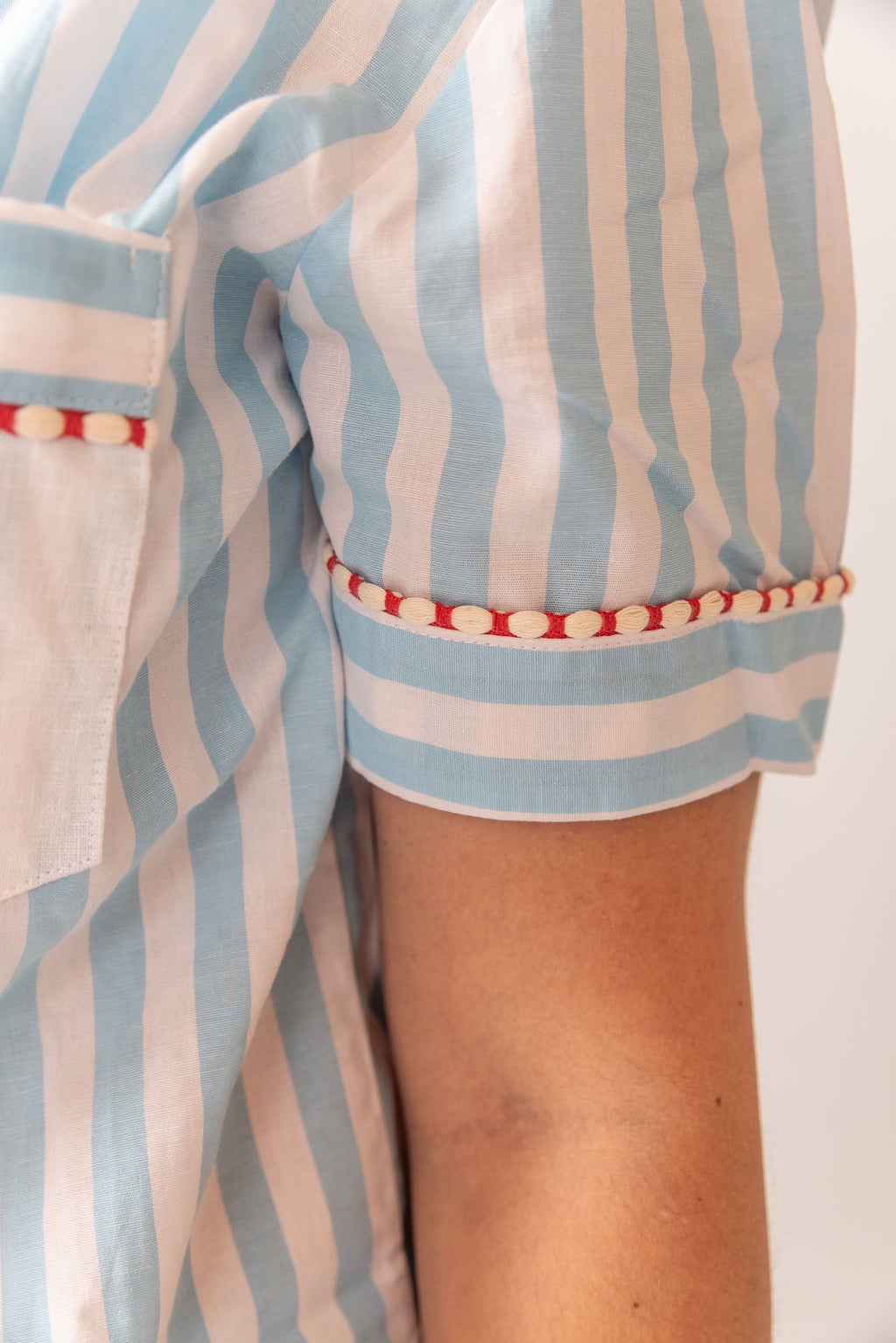 Close-up of a person wearing a blue and white striped outfit with red accents.