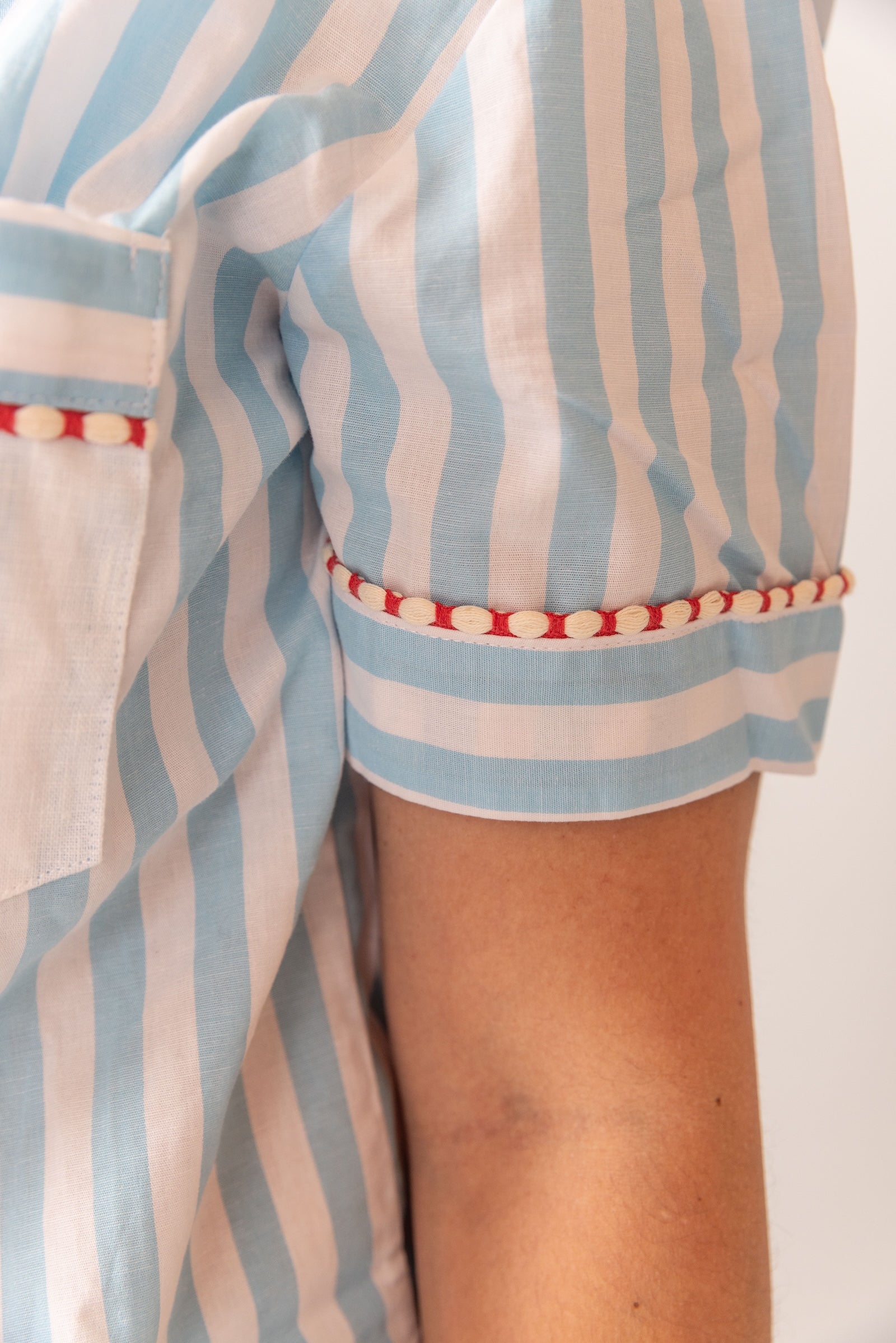 Close-up of a person wearing a blue and white striped outfit with red accents.