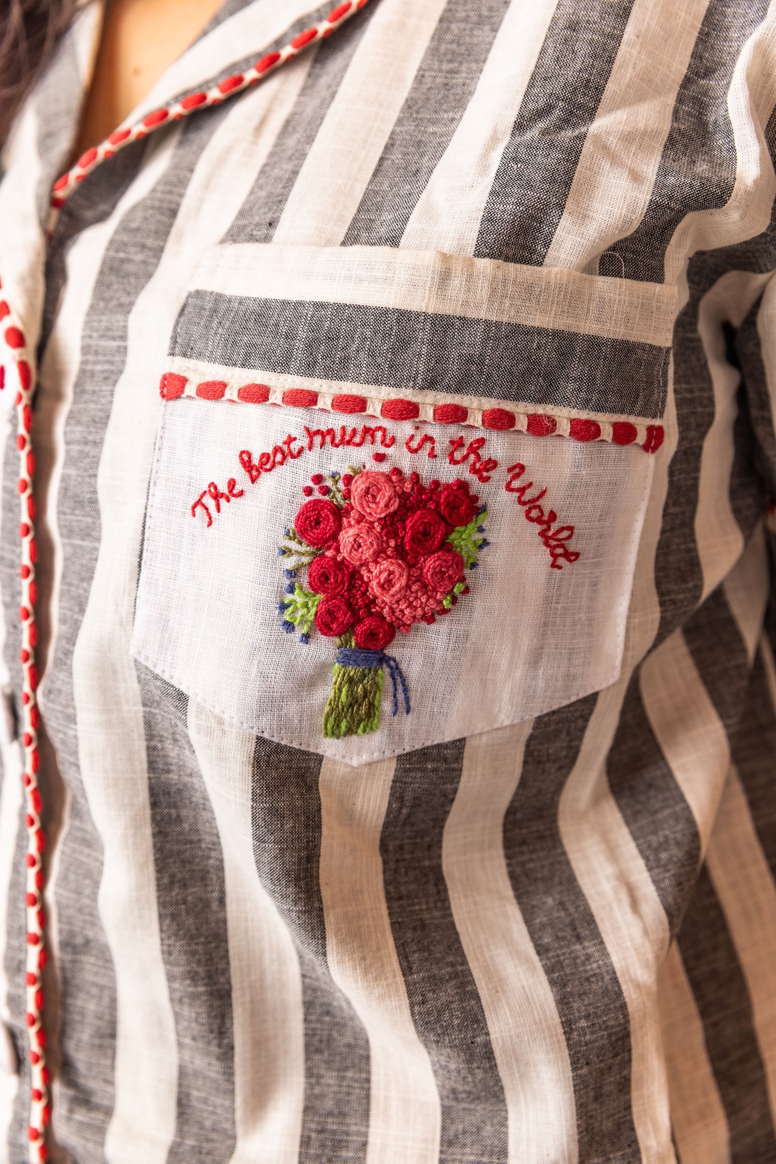 Striped shirt with embroidered pocket featuring flowers and text