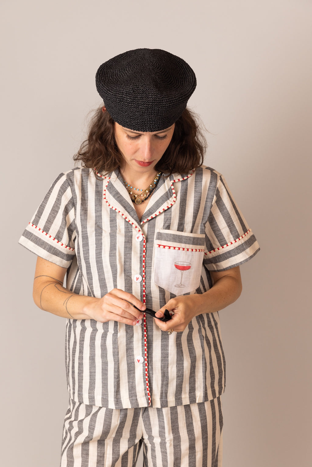 Woman wearing a striped PS61 pajama set with a black cap against a plain background