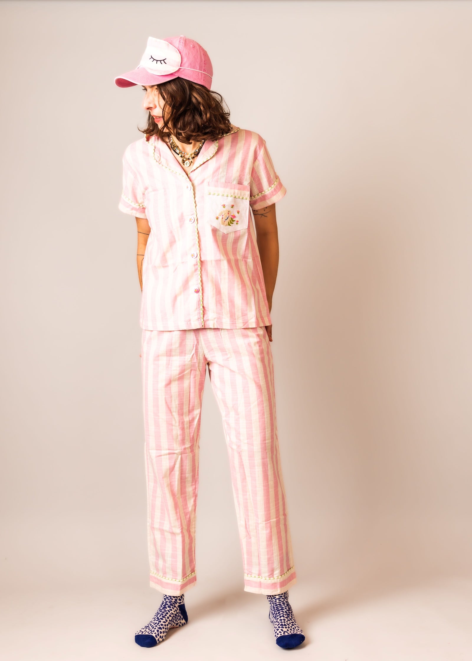 Person wearing a pink pajama set BY PS61 and A PINK CAP 